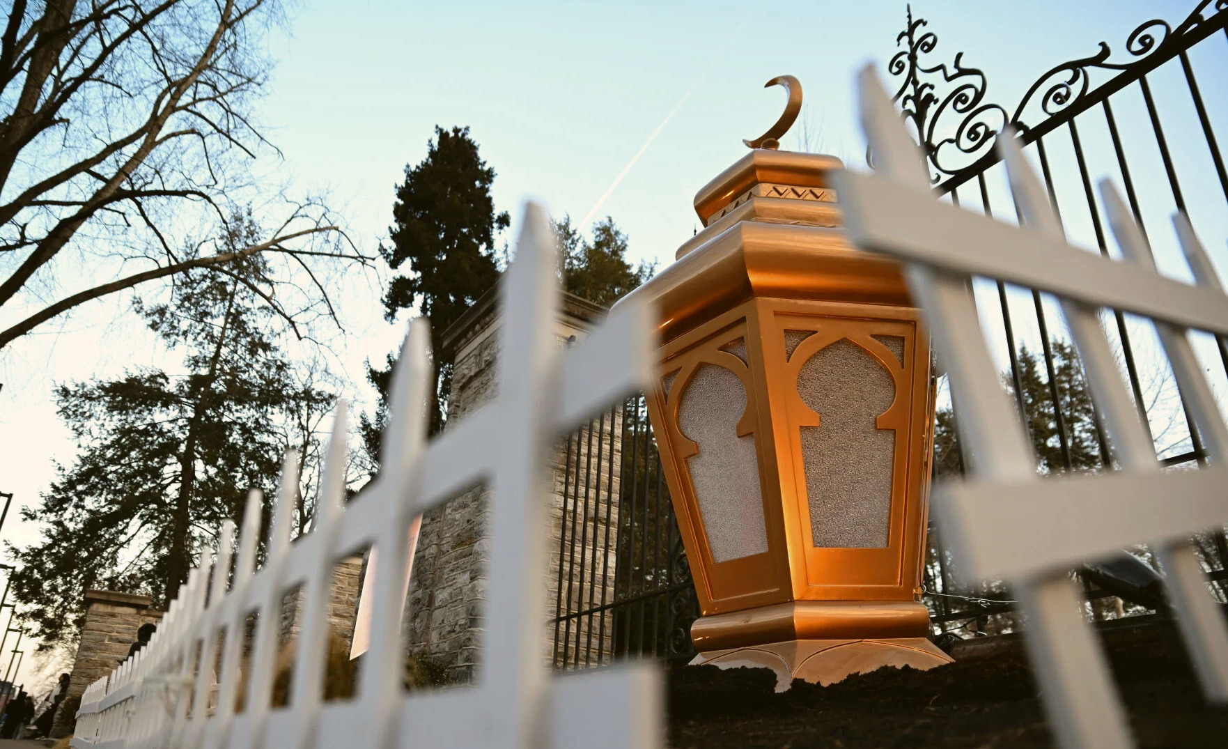 A Ramadan lantern glowing in front of the Old Main gates at Penn State